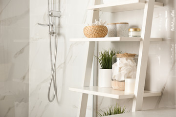 Shelving unit with toiletries in bathroom interior