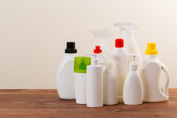 Cleaning product plastic container for house clean on wooden table and gray background . household chemicals