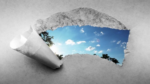 Creative 4k time laps video of fast moving clouds in the blue sky at sunset witn sunflare that are visible through a hole with torn edges in old retro grunge vintage paper.