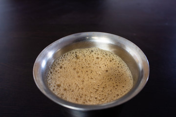 View of filter coffee in a stainless steel tumbler. Chennai is famous for authentic filter coffee.