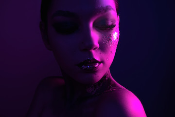 Fashion portrait of a model in neon light. Creative makeup, art makeup.
