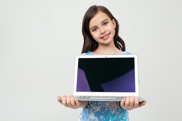 attractive young girl holding a laptop with a mockup for inserting a website on a white studio background