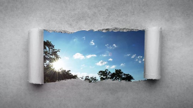 Creative 4k time laps video of fast moving clouds in the blue sky at sunset witn sunflare that are visible through a hole with torn edges in old retro grunge vintage paper.