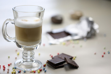 a cup of coffee with milk cappuccino or latte on the table and pieces of chocolad