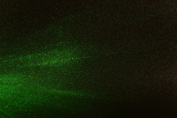 Green rays, lightning and glitter on a black background