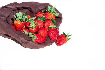 ripe red strawberries in a bag on a white background