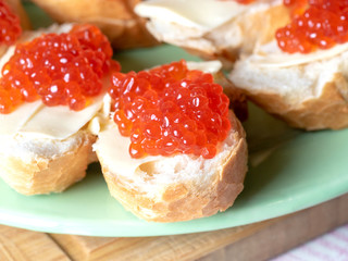 Bread and butter sandwiches with red caviar on a plate. Exquisite and expensive appetizer
