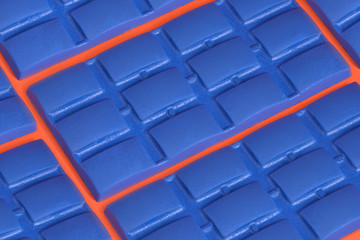 Obraz premium bar of blue chocolate on an orange background
