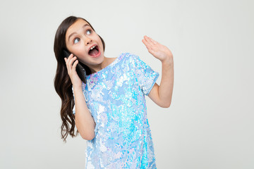 girl emotionally communicates on the phone on a white studio background
