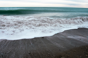 Cold blue sea at sunset. Waves and clouds. Coastline. The waves. The village of Arkhipo-Osipovka.