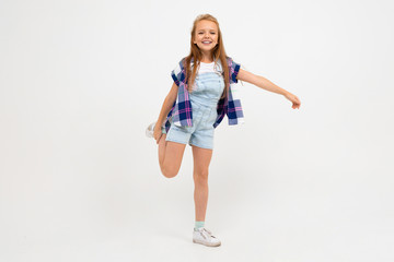 Cheerful teenager girl in stylish clothes dances and enjoy of her life