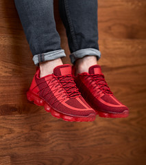 red sport shoes hanging down on the wooden background