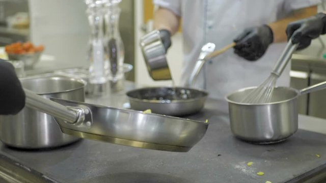 Cooks prepare meals on an electric stove in a professional kitchen in a restaurant or hotel