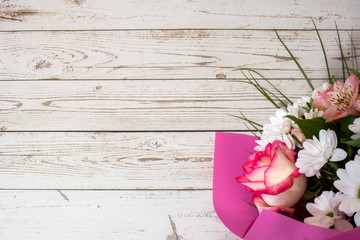 Fototapeta premium Beautiful festive bouquet in pink paper on a white wooden background