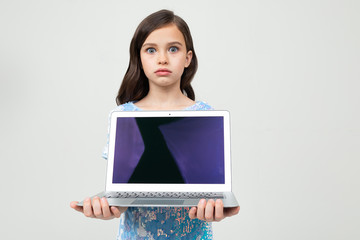portrait of a beautiful teenager girl holding a laptop with a blank screen to insert a website on a...