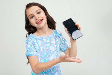 smiling teenager girl shows a blank phone screen with a mockup on an isolated studio background