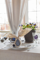 Easter festive spring table setting decoration, bunny ears shaped napkins, dyed eggs, cakes, flowers, selective focus