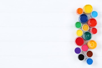 Colorful gouache paints on white wooden table