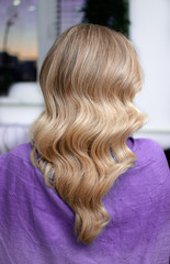 Naklejka premium Blond woman with hairstyle of long wavy hair