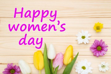 Fototapeta premium Text Happy Womens Day with tulip and chrysanthemum flowers on brown wooden table