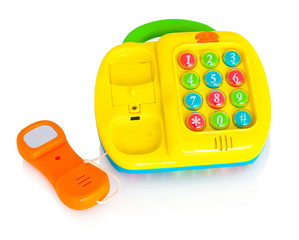 Children's plastic toy phone. Isolated on white background with shadow reflection. With clipping path. Childish telephone with buttons which make sounds. Educational telephone for little children