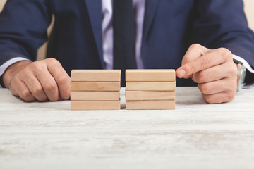 man hand wooden cubes on table