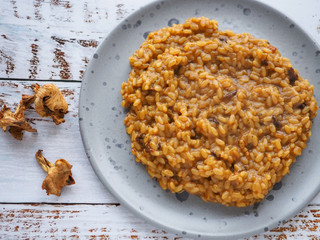 Chanterelle risotto on white wooden background