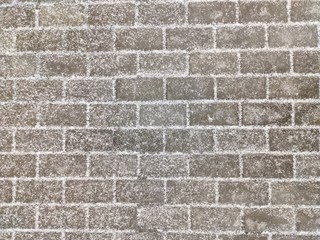 Texture of paving gray rectangular stone tiles covered with light snow