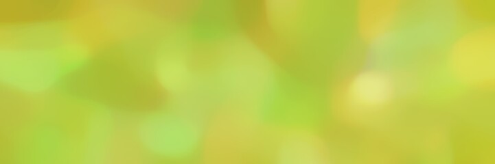 soft blurred landscape format background bokeh graphic with yellow green and dark khaki colors and space for text