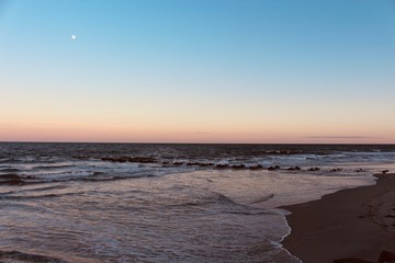 Ocean view on the beach at sunset with the moon