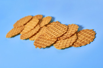 Scattered many thin round waffles on purple background. Losing weight concept