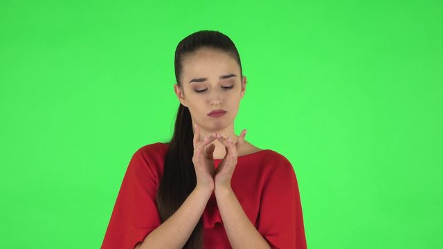 Portrait of pretty young woman is clapping her hands indifferent. Green screen