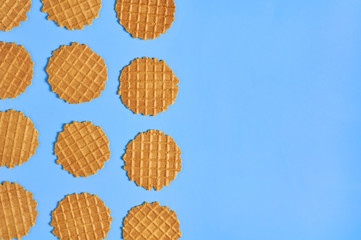 Rows of thin round waffles on purple background. Losing weight concept. Top view. Copy space