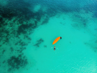 Man and a woman with a kayak in the sea with clear turquoise water. Kayaking, leisure activities on the ocean