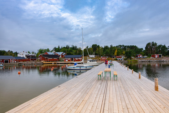 a large wooden pier and a beautiful view of the yachts, town and island of Lappo located on the Aland islands in Finland. view from the pier, landscape.