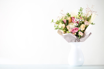 Beautiful flower bouquet in vase on white background