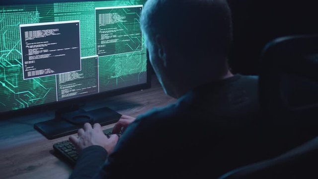 Dirty shot of a man on a computer with granted access to sensitive data.