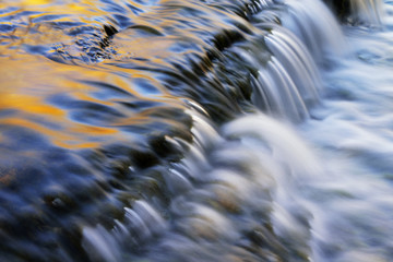 Landscape of Autrain Cascade illuminated by reflected color from sunlit autumn foliage and captured with motion blur, Michigan's Upper Peninsula, USA