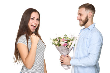 Happy young couple with bouquet of flowers on white background