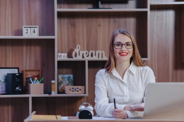 Fototapeta na wymiar Stylish woman works at a laptop desk in a modern office