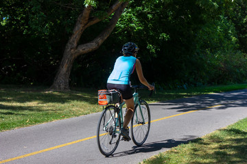 young woman on a bicycle in Canada park wearing helmet