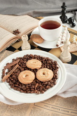 Cookie platter with a cup of tea on a chessboard