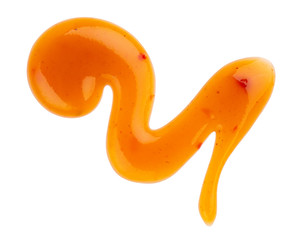 Dripping orange sauce isolated on white background with clipping path. Abstract pattern made of chili sauce. Flat lay, top view, close up.