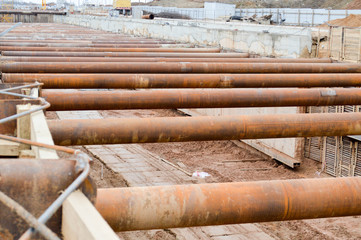 A large huge ditch pit tunnel with reinforcing structures from thick iron pipes of beams and structures at the construction site of the underground metro station line