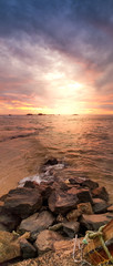 Fototapeta na wymiar Beautiful panoramic photo of sunrise over the ocean and sharp cliffs on the beach