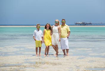 Happy family at the tropical beach during summer vacation . Sun, sand and sea.