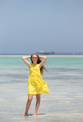 Beautiful girl at the tropical beach during family summer vacation	