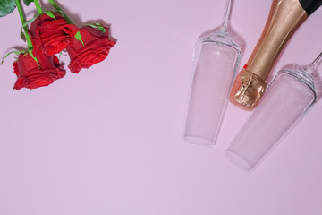 roses with champagne glasses on a pink background with a place for writing