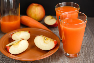 Still life with juice, carrots, and slices of apples.