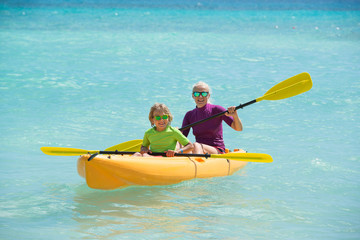 Happy family with kayaks during summer vacations.Mather and son enjoy the time together .
